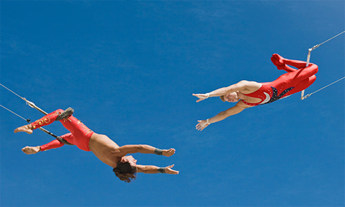 Acrobats hanging from swings