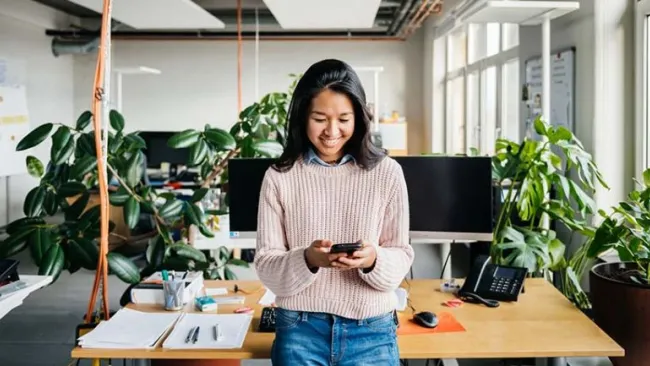 A woman at her workstation looking happy