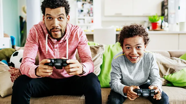An adult and a child playing PS