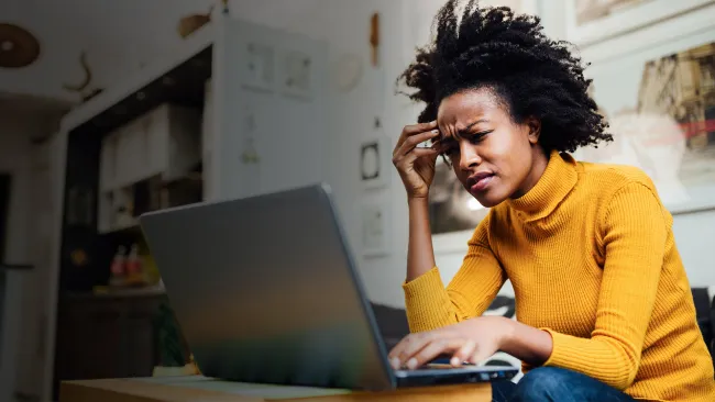 Woman looking frustrated while on her laptop
