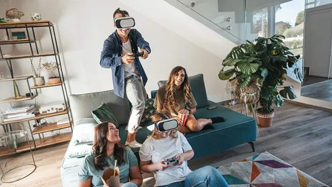 Four people playing video games with VR headsets on