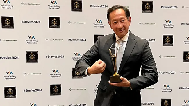 TTEC's Philip Say holding a Gold Stevie Award. 