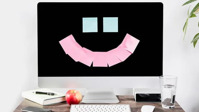 Post-it notes on a monitor in the shape of a smiley face
