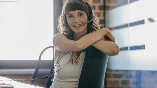 Woman at her desk wearing a headset