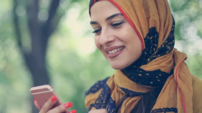 Woman wearing a headscarf using her phone