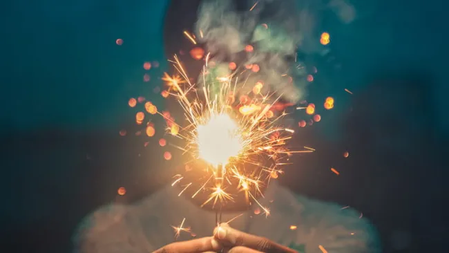 Person holding a sparkler at night