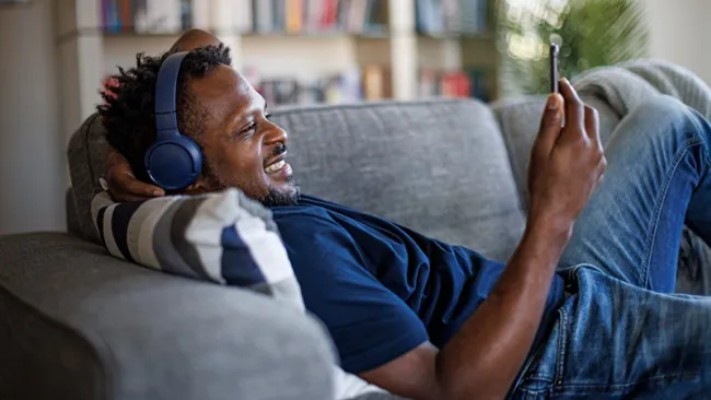 Man relaxing on a couch using his phone