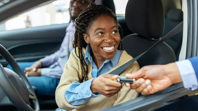 Woman receiving the key for a new car