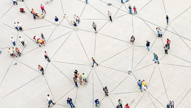 Large group of people walking along a web of lines on the ground