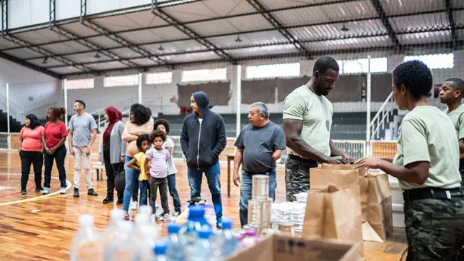 Volunteers handing out water bottles and food to disaster victims