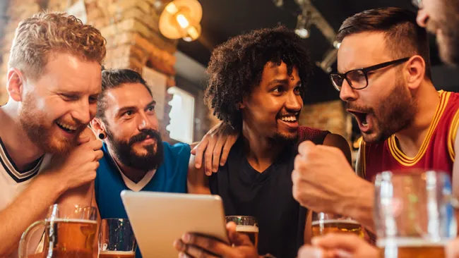 Four men in a sports bar celebrating