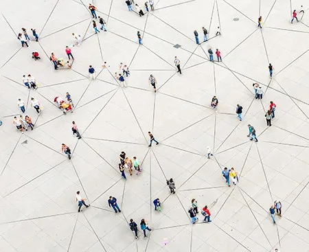 Large group of people walking along a web of lines on the ground