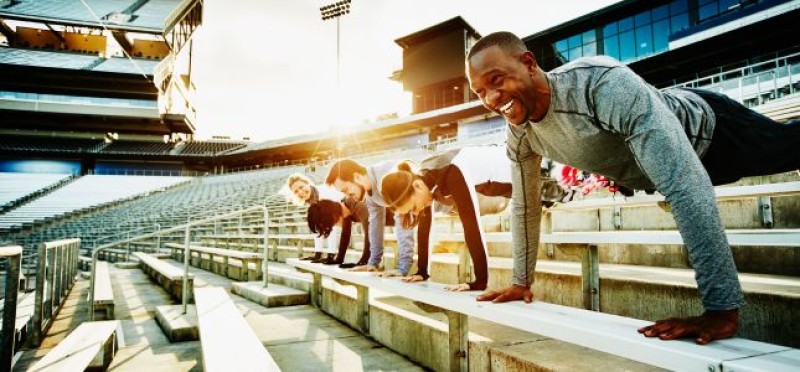 Team doing push ups in a stadium