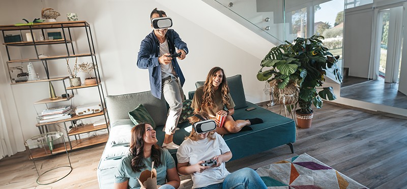 Four people playing video games with VR headsets on