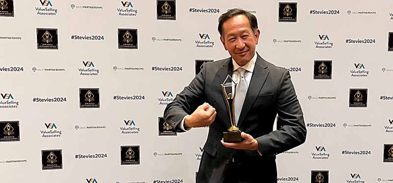 TTEC's Philip Say holding a Gold Stevie Award. 