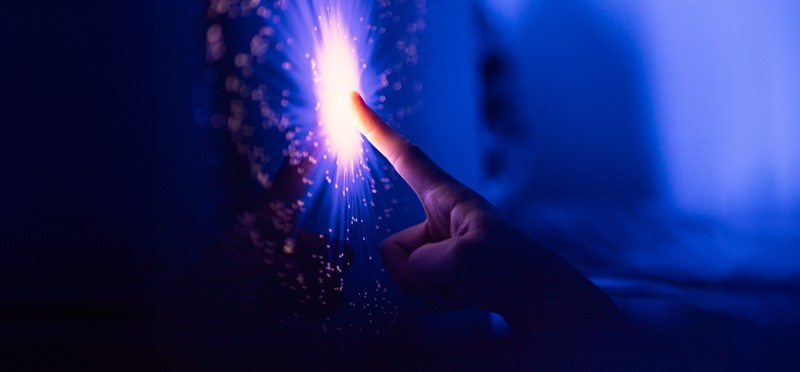 finger in the dark pointing at a bright light of data