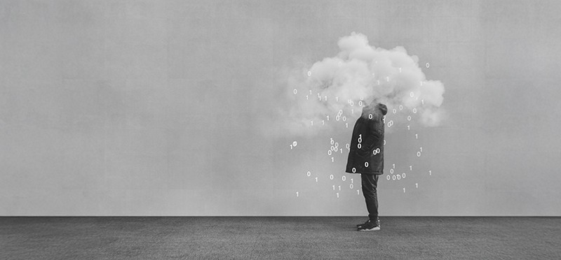 A black and white photo of a person standing, with his or her head obscured by a cloud and the digits 1 and 0 spilling out of the cloud.