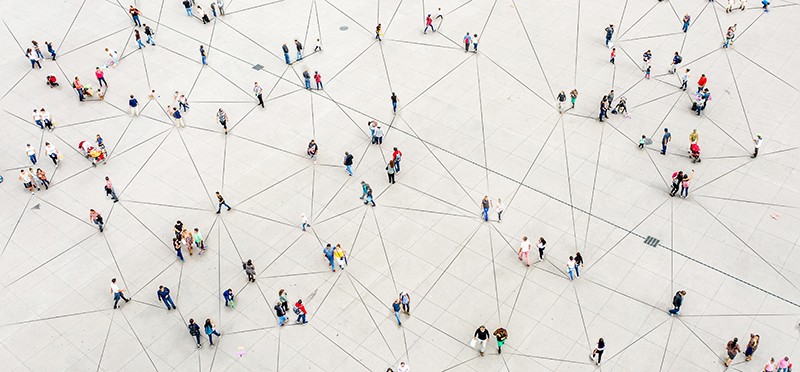 A high-level view from above of people walking, with lines between them, showing they are all connected 