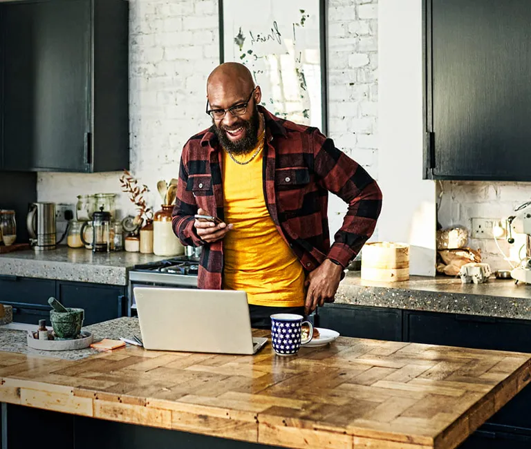 Customer Experience Strategy masthead with man in kitchen using laptop