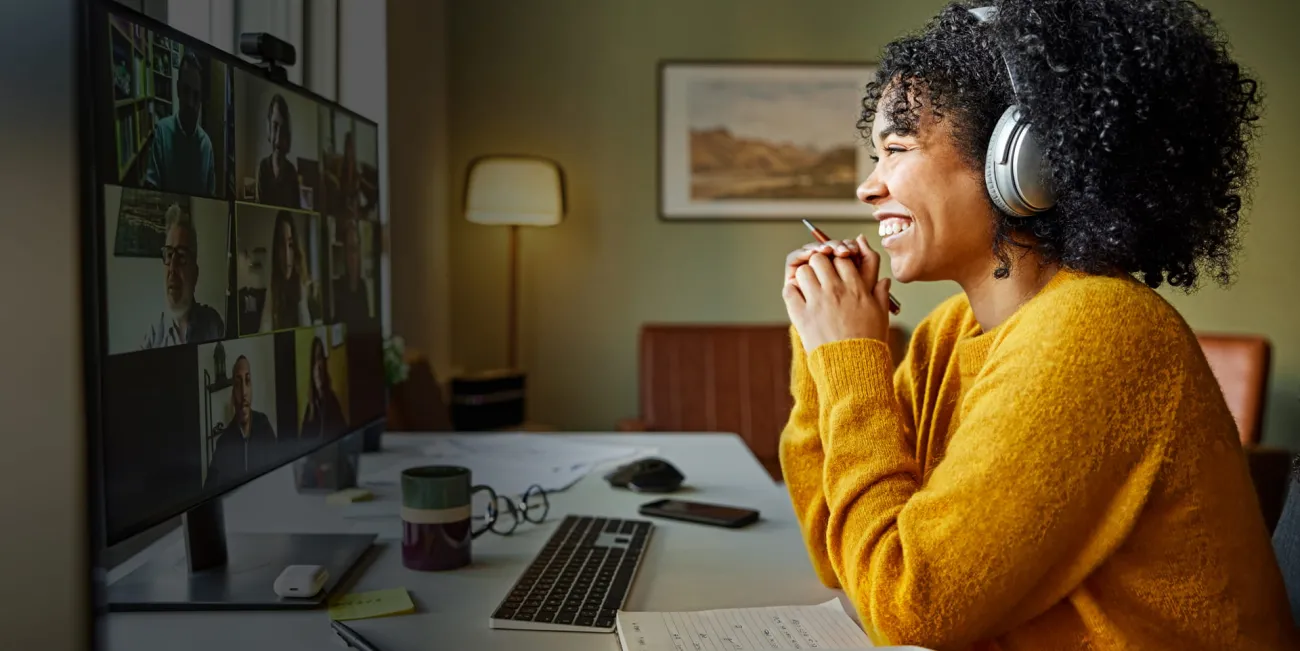 Woman smiling while looking into camera during online meeting