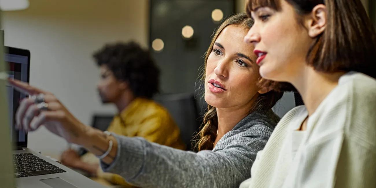 Two women discussing what's on a computer screen