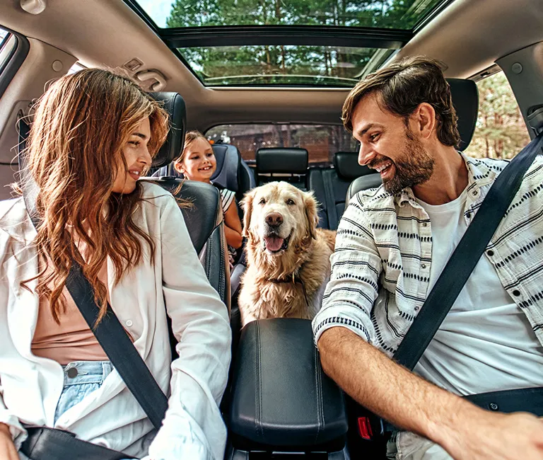 Family in car with pet dog