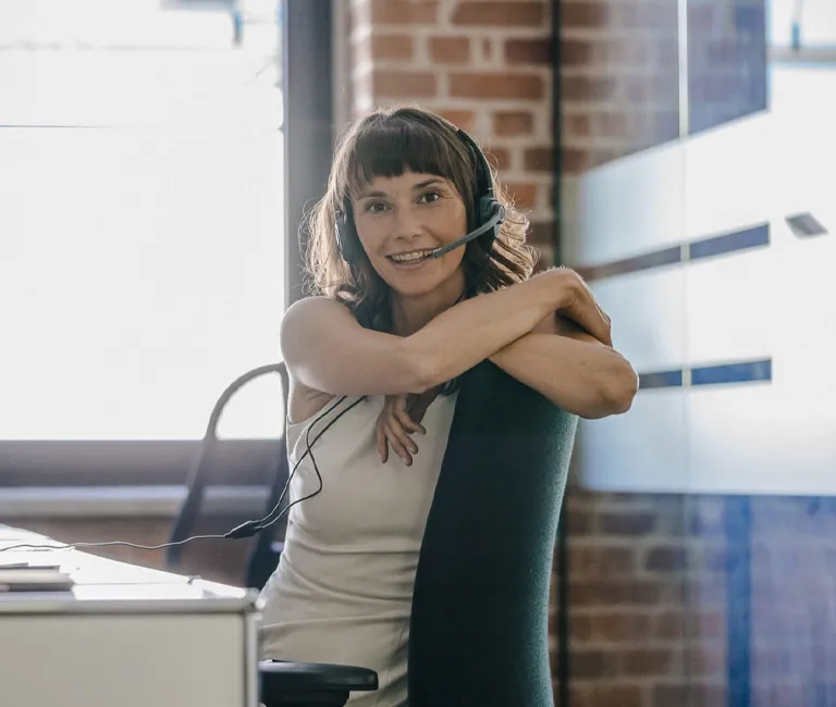 Woman at her desk wearing a headset