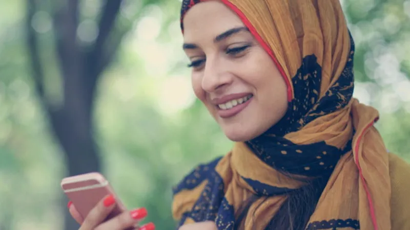Woman wearing a headscarf using her phone