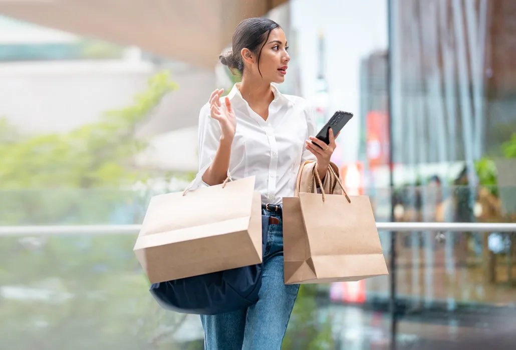 Woman on her phone and carrying shopping bags