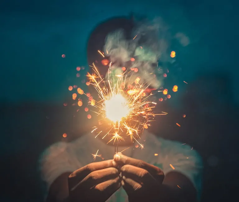 Person holding a sparkler at night