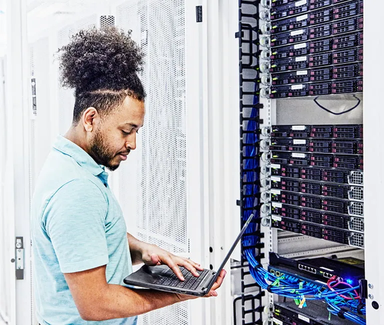 Man working on a laptop in a data center