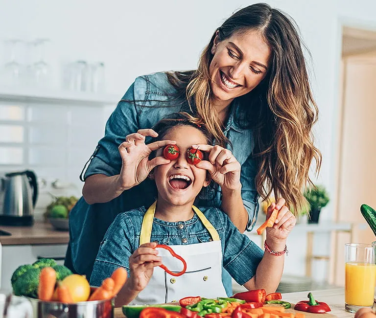 Mother in kitchen cooking with child