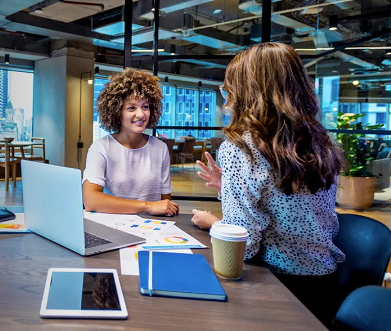 Two people having a discussion in an open office setting