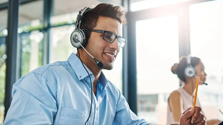 Man working at desk wearing a headset microphone