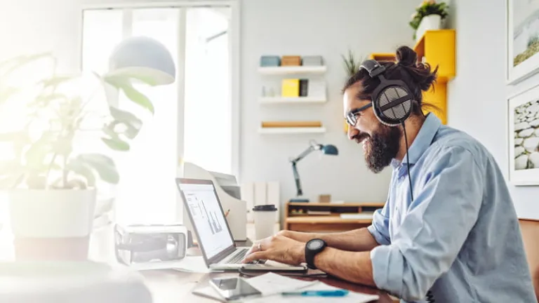 Man working in a home office surrounded by plants