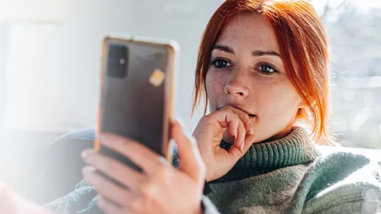 A woman using her phone while sitting on a couch