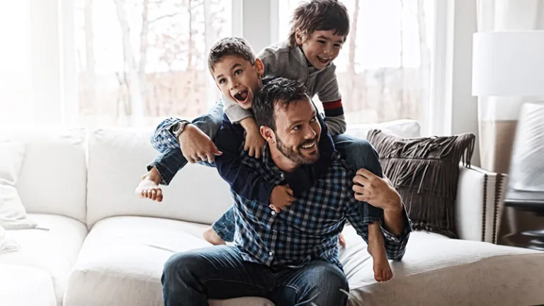 Father playing with his sons in a living room