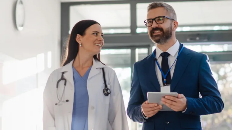 Doctor and executive walking down a hospital hallway